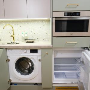 a kitchen with a washing machine and a sink at Apartament Andersa Biłgoraj parking podziemny in Biłgoraj