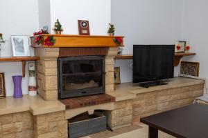 a living room with a fireplace with a flat screen tv at Cheile Valsanului in Brăduleţ