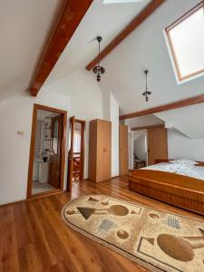 an attic bedroom with a bed and a window at Cheile Valsanului in Brăduleţ