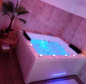 a bath tub with a purple room with a plant in it at Toi et moi à 8 min d etretat in Gerville