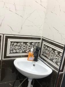 a white sink in a bathroom with black and white tiles at Sweet house in Gyumri