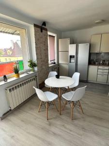 a kitchen with a table and white chairs in a room at Sunny Apartment in Silesia in Czeladź