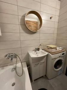 a bathroom with a sink and a washing machine at Sunny Apartment in Silesia in Czeladź