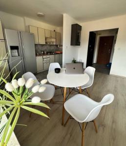 cocina con mesa, sillas y ordenador portátil en Sunny Apartment in Silesia, en Czeladź