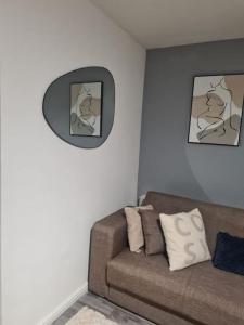 a living room with a couch and a clock on the wall at Cosy Studio 6 with Free Parking in Birmingham