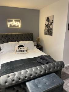 a bedroom with a large bed with a leather bench at Cosy Studio 6 with Free Parking in Birmingham