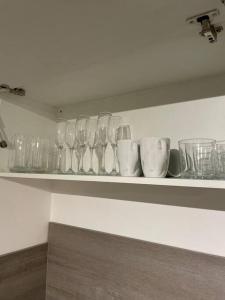 a shelf with wine glasses and cups on it at Cosy Studio 6 with Free Parking in Birmingham