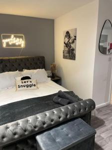 a bedroom with a bed with a black leather couch at Cosy Studio 6 with Free Parking in Birmingham