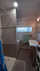 ein Badezimmer mit Dusche und Waschbecken in der Unterkunft Flat with private parking, in the heart of Sete in Sète