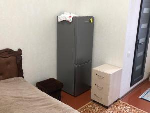 a refrigerator in a room next to a bed at Sweet house in Gyumri