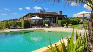 a house with a swimming pool in front of a house at El Ahora in El Eden