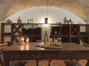 een kamer met een tafel met wijnflessen en kaarsen bij Podere Montaione in Volterra