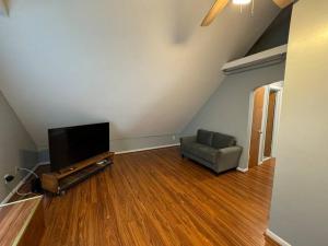 a living room with a couch and a television at Comfy getaway full Apt single bedroom sleeps two! in Niagara Falls
