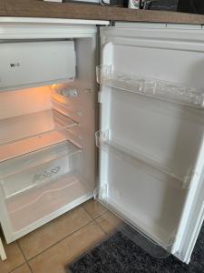un frigorifero vuoto con la porta aperta in una cucina di Apartmán Stupava a Stupava