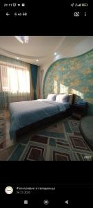 sypialnia z dużym łóżkiem i dużym obrazem w obiekcie Отель Чынгыз 2 w mieście Osz