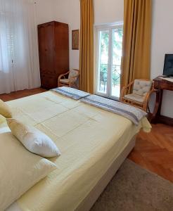 Cama grande en habitación con ventana en Apartments Batala, en Dubrovnik