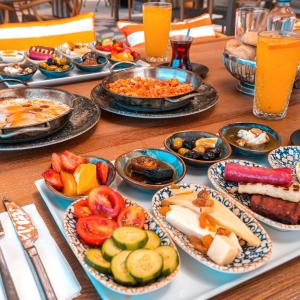 a table with plates of food on a table at Maja Luxury Resort Hotel in Cesme