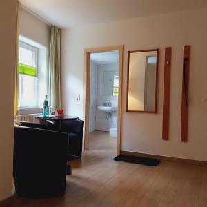 Cette chambre comprend une salle de bains pourvue d'un miroir et d'un lavabo. dans l'établissement Bed and Breakfast Wehlen, à Stadt Wehlen