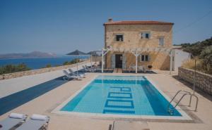 a villa with a swimming pool in front of a building at Margarita's Escape Villa in Kókkinon Khoríon