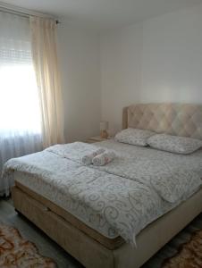 a bedroom with a bed with two stuffed animals on it at Apartmani Dar Lux in Banja Koviljača