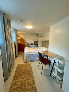 a bedroom with a bed and a desk and a table at Villa Kemi in Kemi