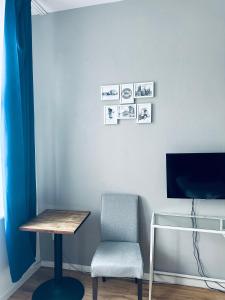 グダニスクにあるHostel Octopus Gdańskのテーブル、椅子、テレビが備わる客室です。