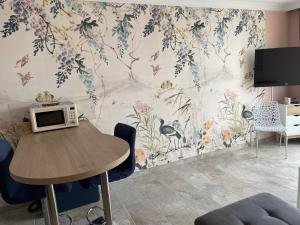 a room with a table with a microwave on a wall at Les pieds dans le sable in Bray-Dunes