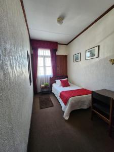 a hotel room with a bed and a window at Hotel Mercurio in Punta Arenas