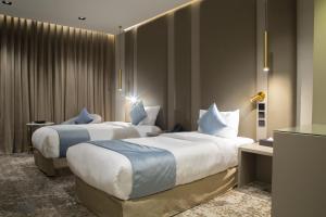 een hotelkamer met twee bedden en een tafel bij فندق راسيا المدينة المنورة in Al Madinah