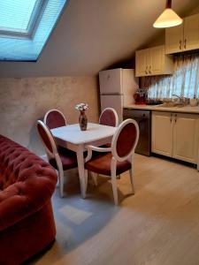 cocina con mesa blanca, sillas, mesa y sofá en Apartament Eva en Bacău