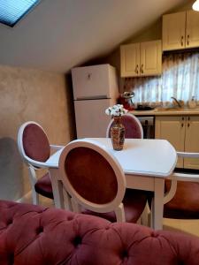 una cocina con mesa y sillas con un jarrón de flores en Apartament Eva en Bacău