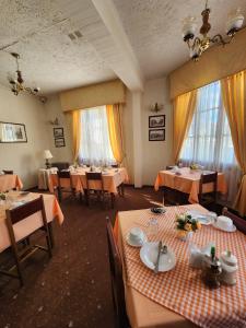 una sala da pranzo con tavoli, sedie e finestre di Hotel Mercurio a Punta Arenas