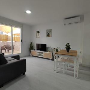 ein Wohnzimmer mit einem Sofa und einem Tisch in der Unterkunft Apartamentos Costa II in Los Alcázares