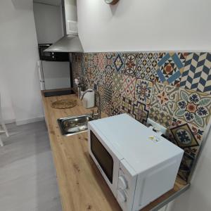 eine Mikrowelle auf der Theke in einer Küche in der Unterkunft Apartamentos Costa II in Los Alcázares