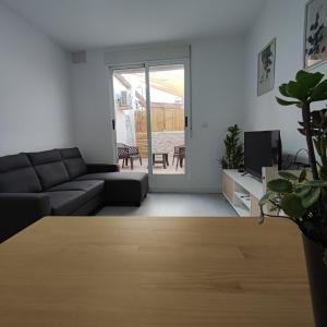 ein Wohnzimmer mit einem Sofa und einem TV in der Unterkunft Apartamentos Costa II in Los Alcázares