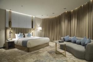 um quarto de hotel com uma cama e um sofá em فندق راسيا المدينة المنورة em Medina