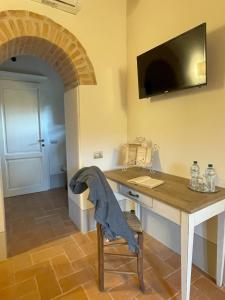 een kamer met een bureau en een tv aan de muur bij Podere Montaione in Volterra