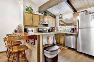 Una cocina con gabinetes de madera y un refrigerador de acero inoxidable. en Smith Summit Chalet at Big Bear~ Base Camp Ski Condo~, en Big Bear Lake