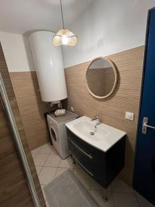 a bathroom with a sink and a mirror and a toilet at Appartement à deux pas du Port in La Tremblade