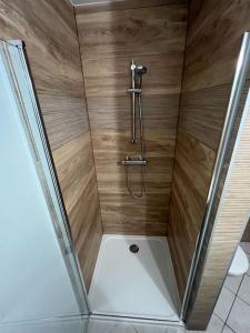a shower with a wooden wall in a bathroom at Appartement à deux pas du Port in La Tremblade
