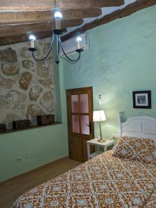 a bedroom with a bed and a stone wall at Alojamiento Rural El ROMERO in Sabiote