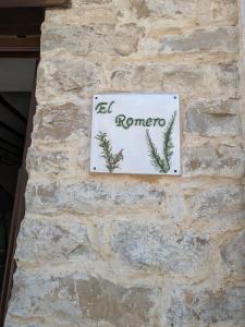 a sign on the side of a stone wall at Alojamiento Rural El ROMERO in Sabiote