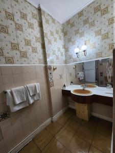 uma casa de banho com um lavatório e um espelho em Hotel Mercurio em Punta Arenas