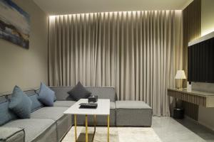 فندق راسيا المدينة المنورة في المدينة المنورة: غرفة معيشة مع أريكة وطاولة