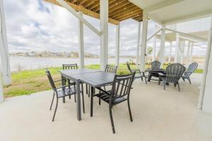 a table and chairs on a porch with a view of the water at Waterfront Seabrook Amazing View Kingbed in Seabrook
