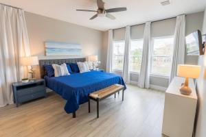 a bedroom with a blue bed and a ceiling fan at Waterfront Seabrook Amazing View Kingbed in Seabrook