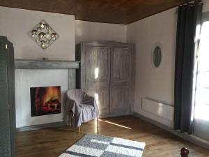 a living room with a fireplace and a chair at Maison au calme vue sur les montagnes in Asté