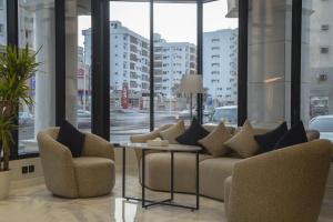 فندق راسيا المدينة المنورة في المدينة المنورة: غرفة معيشة مع كرسيين وطاولة ونوافذ