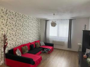 sala de estar con sofá rojo frente a la pared en Apartmán pod Kalváriou, en Oščadnica
