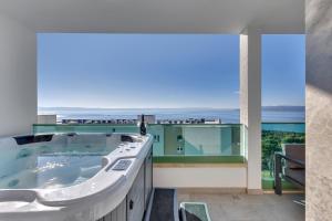 a bathroom with a tub with a view of the ocean at Exclusive Penthouse Big Blue with private Jacuzzi in Makarska